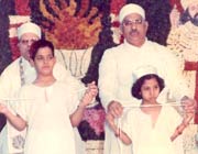 A boy and young girl wearing the sudreh and holding the kusti