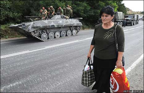 Một phụ nữ Gruzia đi bộ ngang qua các xe tăng Nga