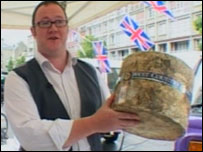Man holding a whole cheese