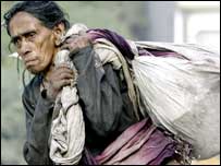 مظفرآباد میں زلزلے سے متاثرہ خاتون امداد لیے ہوئے