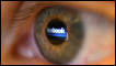 An eye with facebook reflected in it