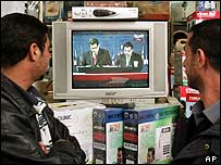 Muži sledující vyhlašování výsledků