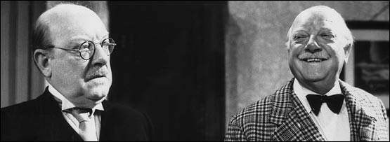 Two men - one laughing, one frowning