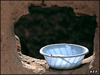 کودک افغان پشت یک دیواره سوراخ شده در هلمند