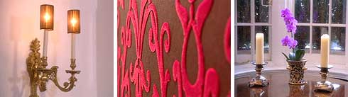 Candle style light fitting, flocked wallpaper and candles on a table