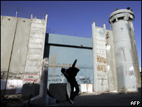 Manifestante palestino atira pedra em torre de controle israelense na Cisjordânia