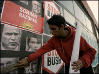 Duvara Bush karşıtı posterler yapıştıran bir genç