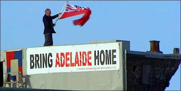 Paeter Maddison waving flag from deck of City of Adelaide