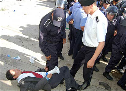 Cảnh sát đè một người biểu tình xuống đất 