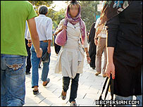 مردم در حال عبور و مرور در پیاده رویی در تهران