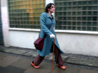 Kate Ansell strides through the damp city streets, assisted by her walking stick