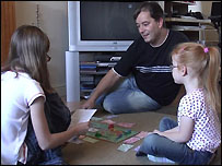 Man playing monopoly with two children
