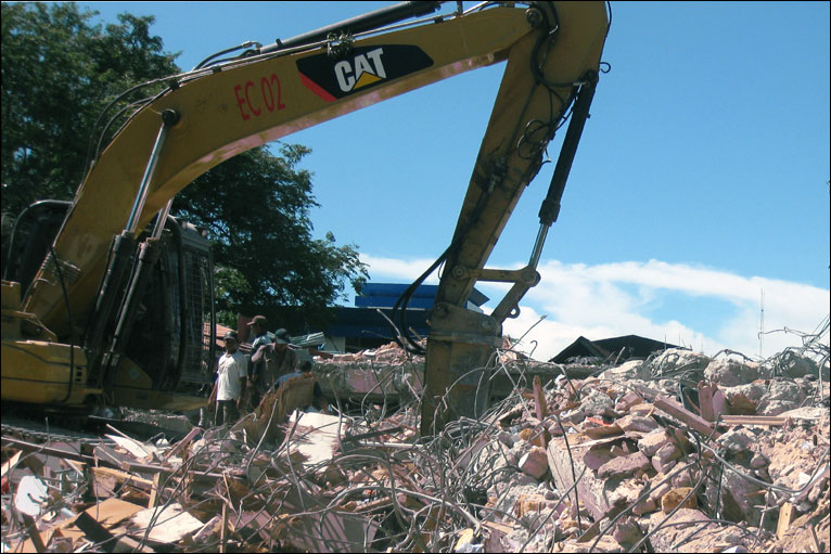Peralatan berat dikerahkan untuk membongkar dan menyingkirkan puing bangunan yang ambruk akibat gempa di Padang, Sumatera Barat. Foto oleh Andreas Nugroho