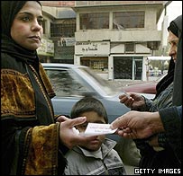 Eleitora recebe folheto de campanha em Bagdá