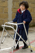 A disabled girl in school uniform, uaing a walker