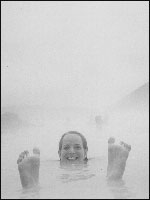 Steff in a hot spring, surrounded by geysers