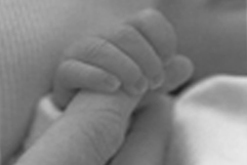 Baby holding parent's finger