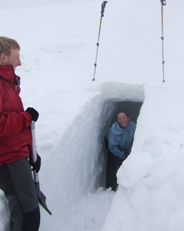 Man and woman shovelling at snow-hole entrance