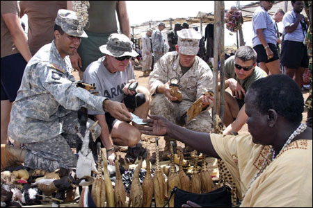 American soldiers in Uganda for a training exercise buy souvenirs at a market in Kitgum