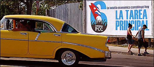 Un coche pasa frente a un cartel en La Habana, Cuba