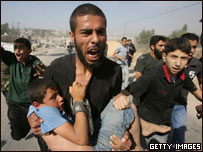 Palestino carrega criança ferida enquanto foge de ataque aéreo israelense na Faixa de Gaza