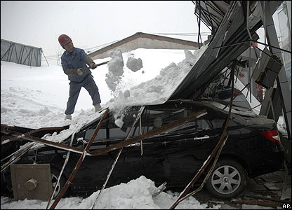 Một công nhân đang dùng xẻng gạt tuyết từ một khu trưng bày xe hơi bị sập tại Vũ Hán, ngày 28/01/2008