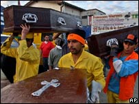 Funcionários municipais carregam corpos das vítimas