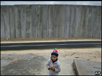 Menino palestino em frente à barreira israelense no vilarejo de Masha, Cisjordânia