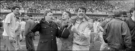 An injured fan is carried on the pitch