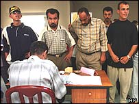 Umm Kasr'da kütüklere kaydolmak için sıraya giden seçmenler