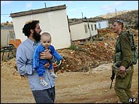 Homem passeia com bebê no assentamento de Givat Assaf