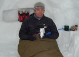 Mountaineer sitting up inside snow-hole (Image courtesy of John Armstrong, Glenmore Lodge)
