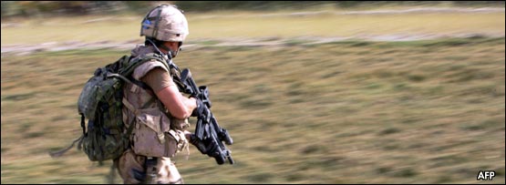 A soldier carrying a gun