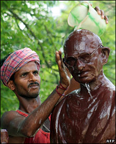 A man washing a statue of Gandhi in India