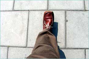 Person avoiding gaps between pavement slabs