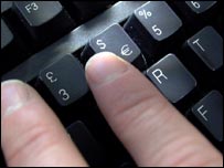 A hand typing at a keyboard