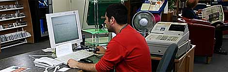 man sitting at computer in a library