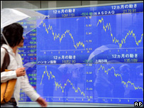 Pedestre observa indicadores em baixa no Japão