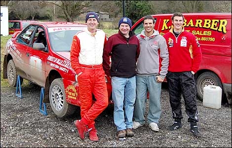 Nigel Drew stands in front of his Subaru rally car with brother Rob and nephew's Paul and Craig