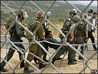 İsrail askerlerinin taşıdığı bir protestocu