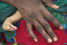 Mother rests her hand on the leg of her son.