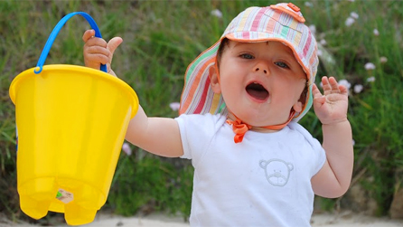 baby on a beach with bucket and spade