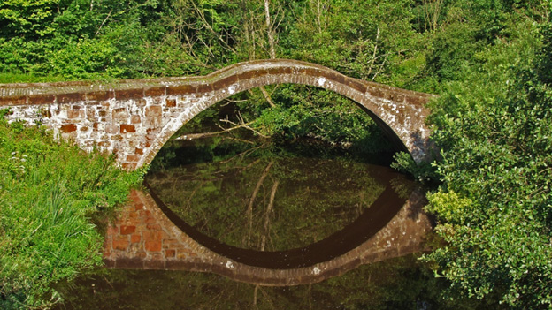 The Roman Bridge at Motherwell and its clear reflection mirrored in the river below