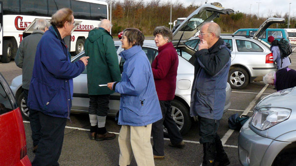 People beside parked cars