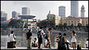 People sit by the Singapore River 