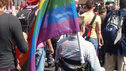 Man in wheelchair with gay pride flag