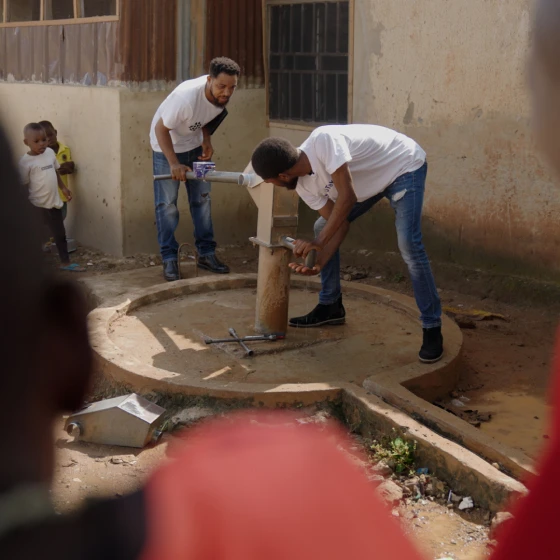 Two men operating a water pump.